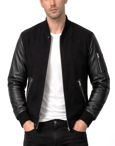 Man wearing a black leather jacket over a white shirt on a white background